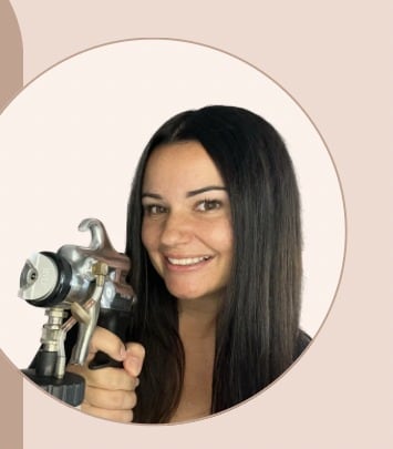Ashley, Master Spray Tan Artist and owner of Glow by Ashley, holding her airbrush